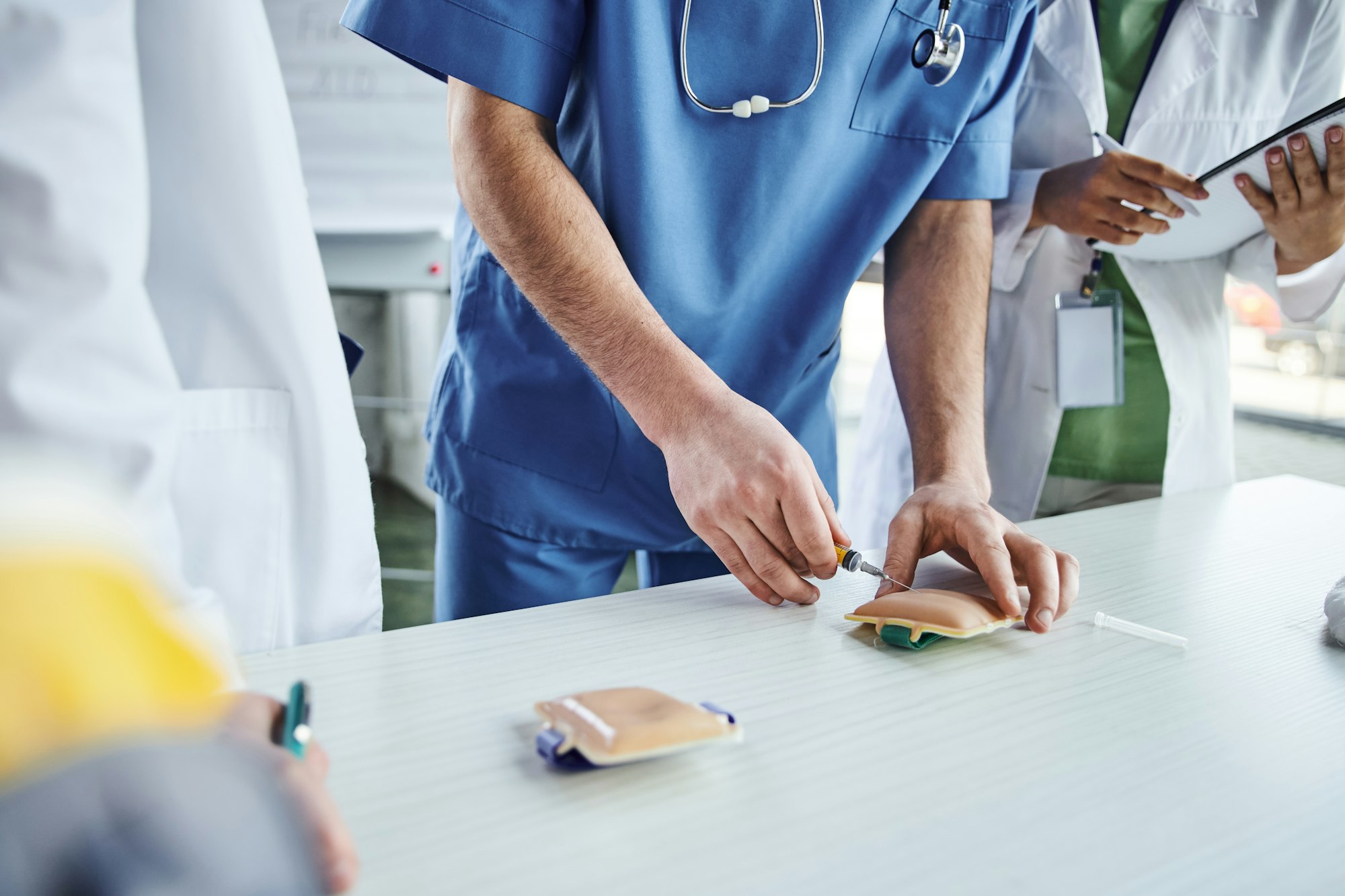 first aid hands-on learning, cropped view of medical instructor in uniform practicing