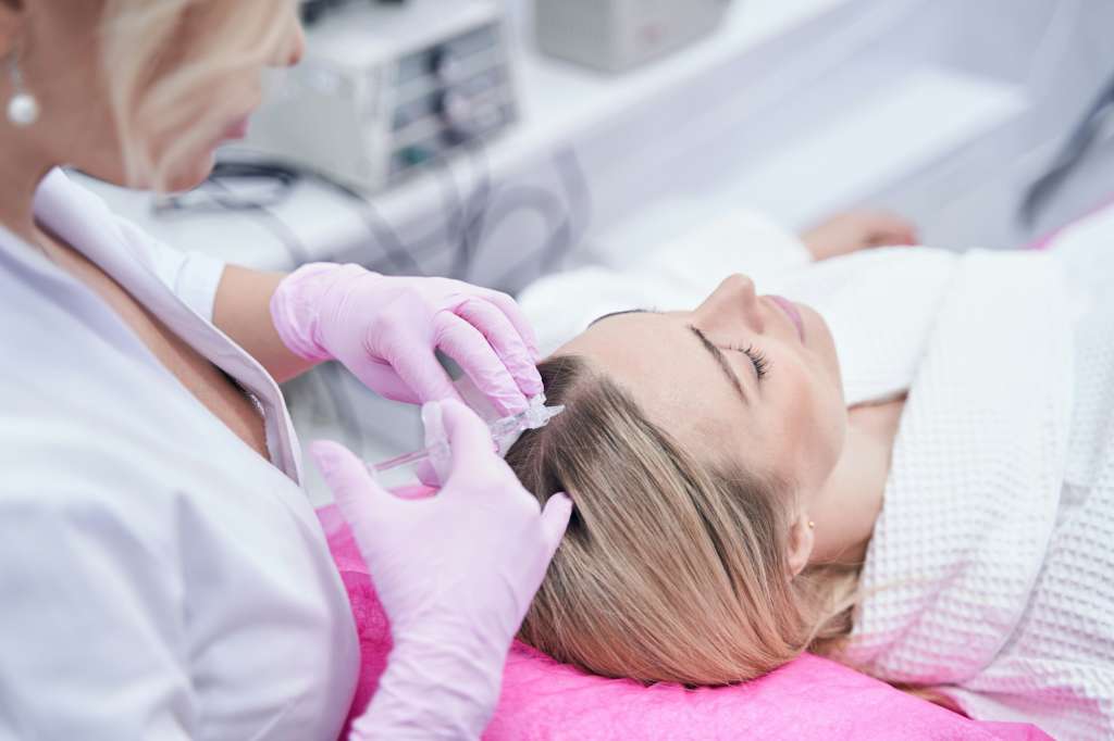 Trichologist conducting mesotherapy hair treatment on client